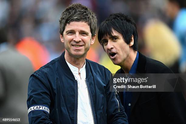 Noel Gallagher and Johnny Marr celebrate at the end of the Barclays Premier League match between Manchester City and West Ham United at the Etihad...