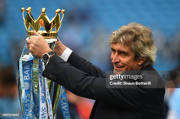 The Manchester City Manager Manuel Pellegrini poses with the Premier League trophy at the end of the Barclays Premier League match between Manchester...