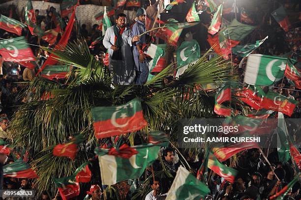 Supporters of cricketer-turned politician and chairman of Pakistan Tehreek-e-Insaf or Movement for Justice party, Imran Khan , wave party flags as...