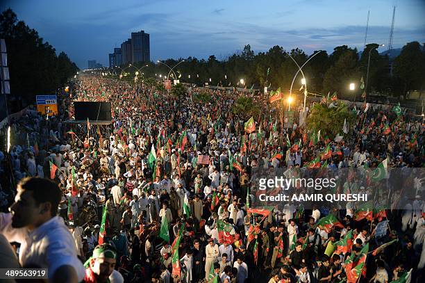 Supporters of cricketer-turned politician and chairman of Pakistan Tehreek-e-Insaf or Movement for Justice party, Imran Khan , wave party flags as...