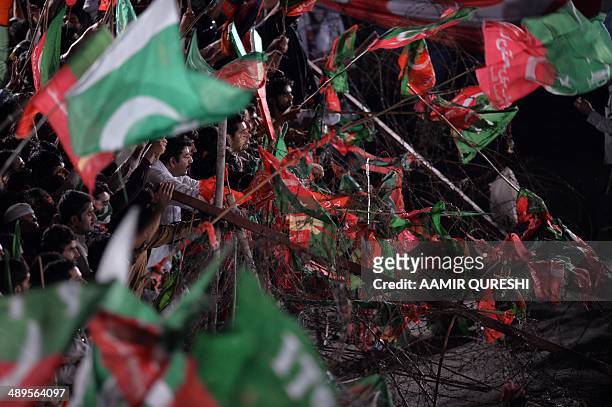 Supporters of cricketer-turned politician and chairman of Pakistan Tehreek-e-Insaf or Movement for Justice party, Imran Khan , wave party flags as...