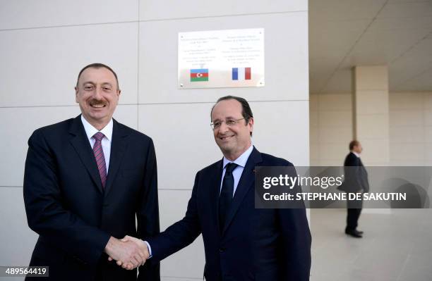 Azerbaijan President Ilham Aliyev and French President Francois Hollande shake hands during the inauguration of the French school of Ville Blanche on...