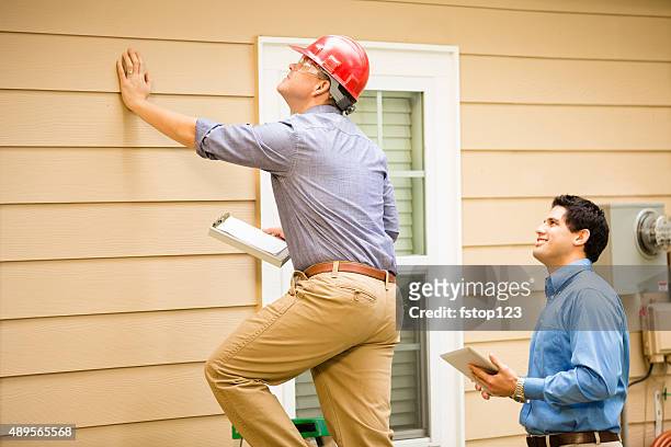 inspectores o azul empleados administrativos examinar la construcción de pared, base.  al aire libre. - seguro del hogar fotografías e imágenes de stock