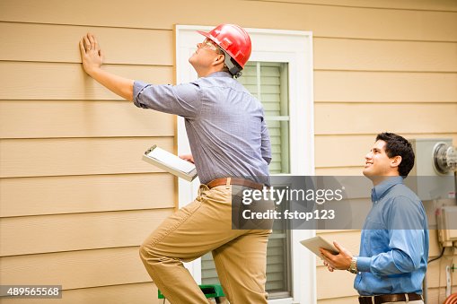Inspectors or blue collar workers examine building wall, foundation. Outdoors. Inspectors or blue collar workers examine building wall, foundation. Outdoors.