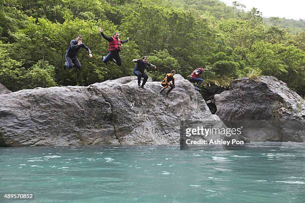 Joey Fatone and participants jump into the river from a rock as Fatone takes part in river tracing and trekking on August 31, 2015 in the Hualien...