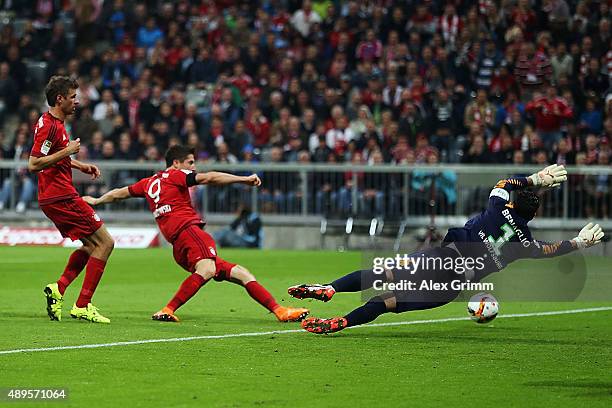 Robert Lewandowski of Muenchen scores his team's first goal against goalkeeper Diego Benaglio of Wolfsburg during the Bundesliga match between FC...