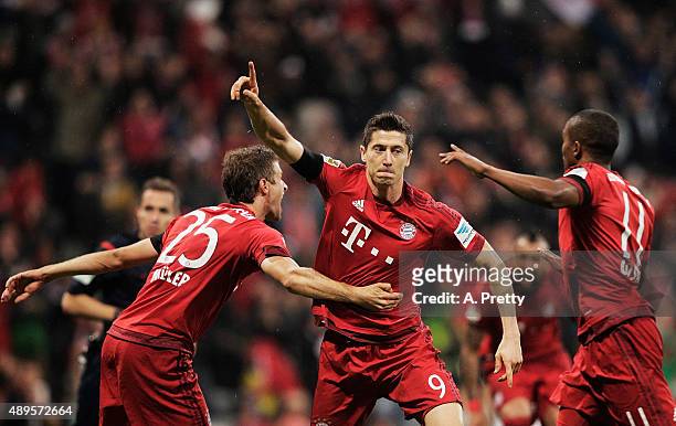 Robert Lewandowski of Bayern Munich celebrates scoring his 1st goal during the Bundesliga match between FC Bayern Muenchen and VfL Wolfsburg at...