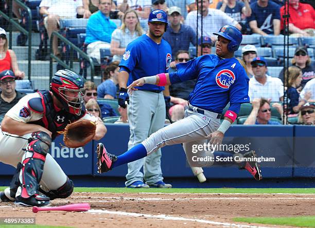 Starlin Castro of the Chicago Cubs scores a 2nd inning run against Evan Gattis of the Atlanta Braves at Turner Field on May 11, 2014 in Atlanta,...