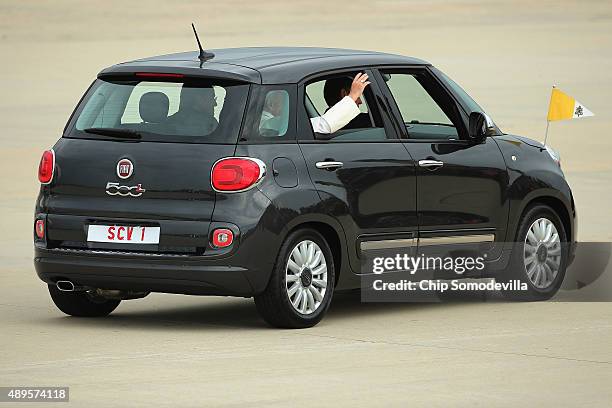 Pope Francis waves from the back of his Fiat after arriving from Cuba September 22, 2015 at Joint Base Andrews, Maryland. Francis will be visiting...