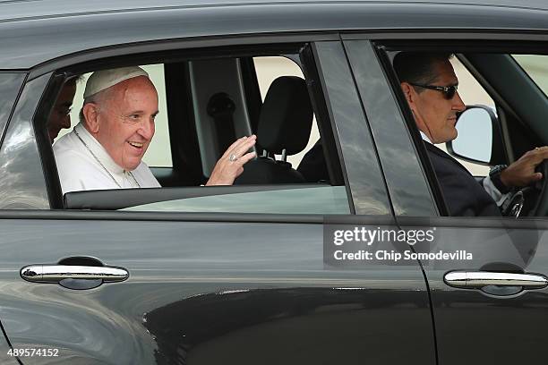 Pope Francis waves from the back of his Fiat after arriving from Cuba September 22, 2015 at Joint Base Andrews, Maryland. Francis will be visiting...