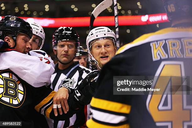 Zac Rinaldo of the Boston Bruins, David Krejci and Tim Gleason of the Washington Capitals are separated during a fight in the first period at TD...