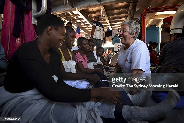 Carol Nagy, a medical team leader for Medecins Sans Frontieres, examines refugees aboard the rescue vessel, MY Phoenix, August 27, 2015. Over 400...