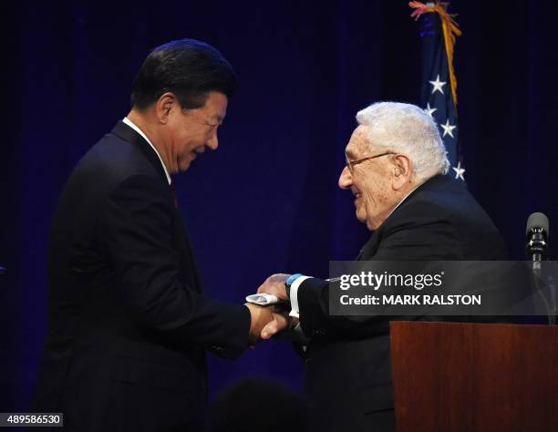 Chinese President Xi Jinping is greeted by former US Secretary of State Henry Kissinger during his welcoming banquet at the start of his visit to the...