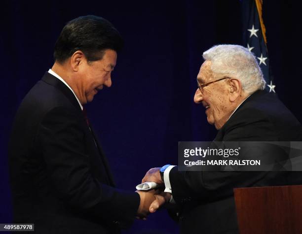 Chinese President Xi Jinping is greeted by former US Secretary of State Henry Kissinger during his welcoming banquet at the start of his visit to the...