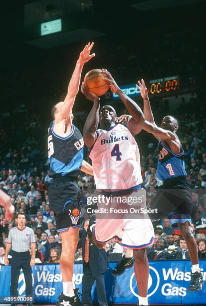 Chris Webber of the Washington Bullets looks to shoot over Danny Ferry and Terrell Brandon of the Cleveland Cavaliers during an NBA basketball game...