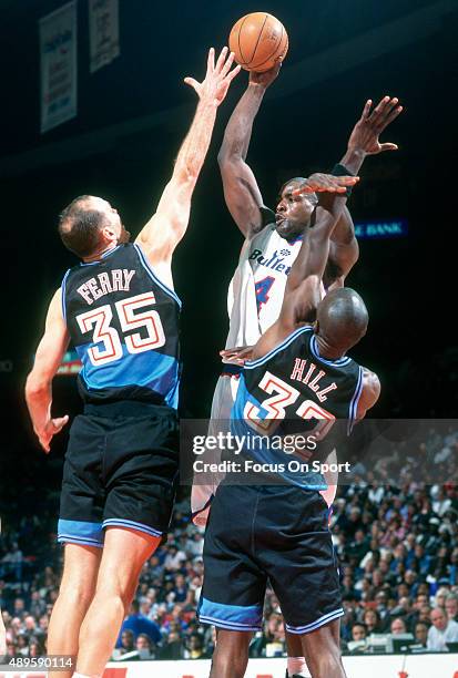 Chris Webber of the Washington Bullets look to pass over the top of Danny Ferry and Tyrone Hill of the Cleveland Cavaliers during an NBA basketball...