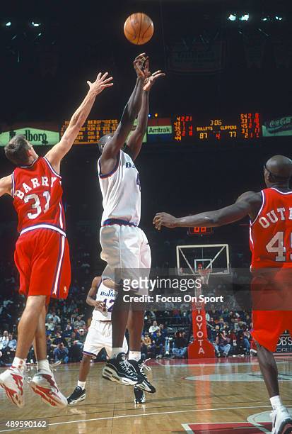 Chris Webber of the Washington Bullets shoots over Brent Barry of the Los Angeles Clippers during an NBA basketball game circa 1997 at the Capital...
