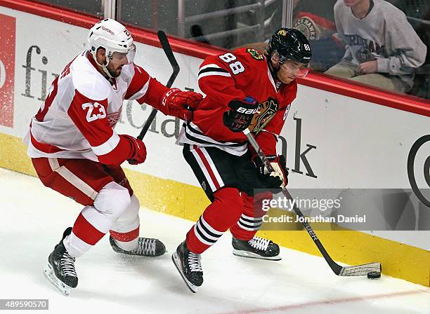 Patrick Kane of the Chicago Blackhawks is pressured by Brian Lashoff of the Detroit Red Wings during a preseason game at the United Center on...