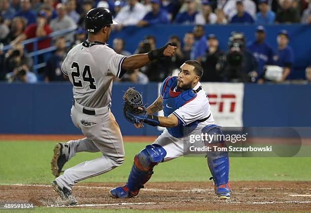 Chris Young of the New York Yankees is tagged out at home plate as he tries to score on a sacrifice fly attempt in the ninth inning during MLB game...