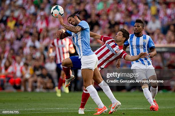 Marcos A. Angeleri of Malaga CF wins the header after Diego Ribas of Atletico de Madrid during the La Liga match between Club Atletico de Madrid and...