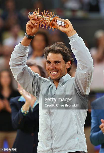 Rafael Nadal of Spain holds his winners trophy aloft after victory over Kei Nishikori of Japan in their final match during day nine of the Mutua...