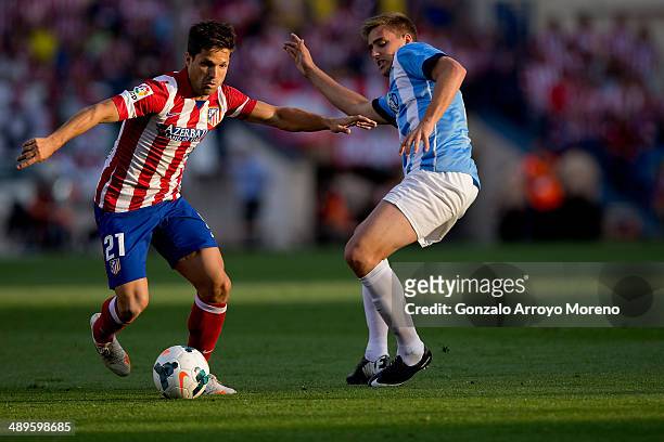 Diego Ribas of Atletico de Madrid competes for the ball with Juan Miguel Jimenez alias Juanmi of Malaga CF during the La Liga match between Club...