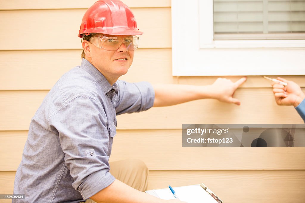 Inspector ou os trabalhadores de colarinho azul examina a parede de construção, janela. Ao ar livre.