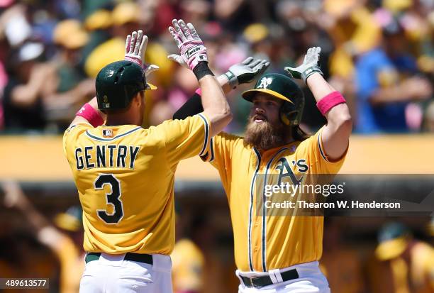 Derek Norris of the Oakland Athletics is congratulated by Craig Gentry after Norris hit a three-run homer in the bottom of the second inning against...