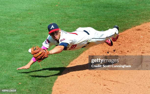 Andrelton Simmons of the Atlanta Braves is unable to hold on to an 8th inning line drive against the Chicago Cubs at Turner Field on May 11, 2014 in...