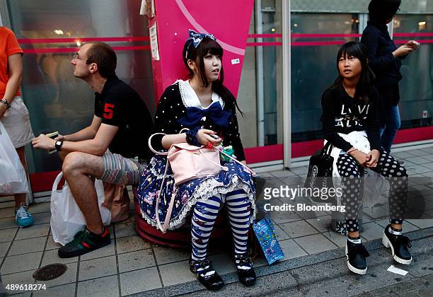 Shoppers rest on the sidewalk of Takeshita Street in the Harajuku area of Tokyo, Japan, on Tuesday, Sept. 22, 2015. The Bank of Japan this month...