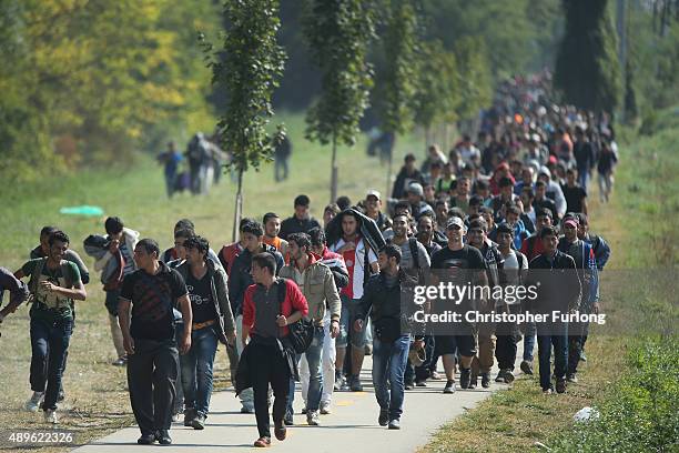 Hundreds of migrants who arrived by train at Hegyeshalom on the Hungarian and Austrian border walk the four kilometres into Austria on September 23,...