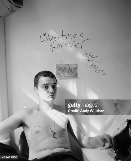 English singer-songwriter and musician Pete Doherty, of The Libertines, circa 2003. Written on the wall behind him are the words 'Libertines Forever,...