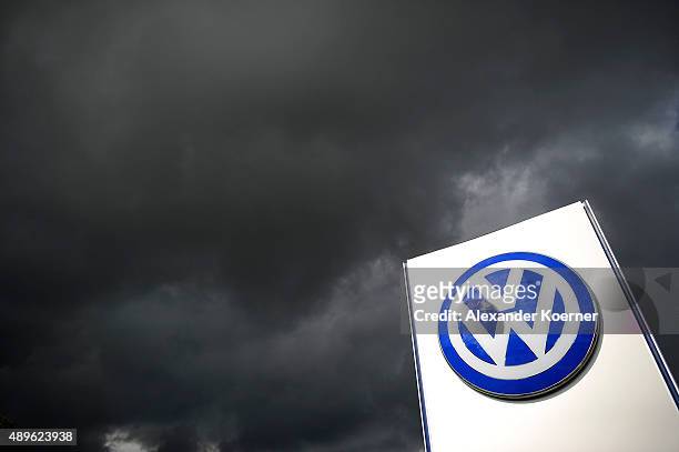 Rain clouds are seen over a Volkswagen symbol at the main entrance gate at Volkswagen production plant on September 23, 2015 in Wolfsburg, Germany....