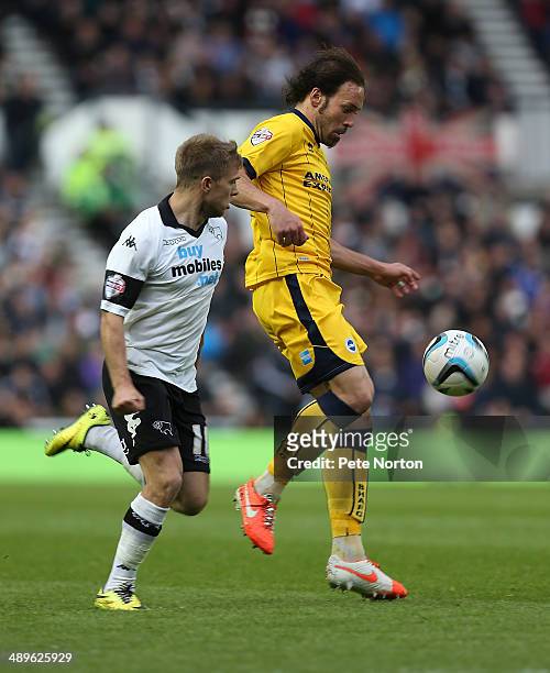 Inigo Calderon of Brighton & Hove Albion looks to control the ball watched by Jamie Ward of Derby County during the Sky Bet Championship Semi Final...