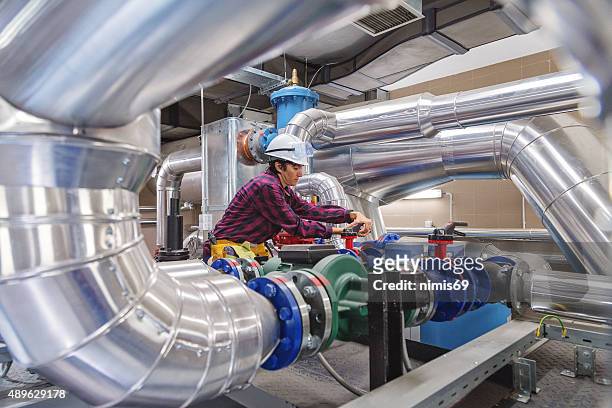 technician working on valve in factory or utility - luchtkanaal stockfoto's en -beelden