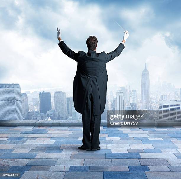 conductor on top of building in city - musical conductor stock pictures, royalty-free photos & images