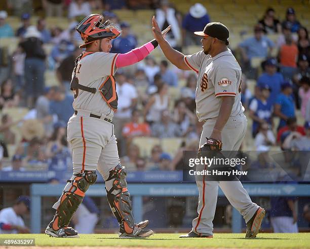 Hector Sanchez of the San Francisco Giants celebrates a 7-4 win over the Los Angeles Dodgers with Jean Machi at Dodger Stadium on May 11, 2014 in Los...