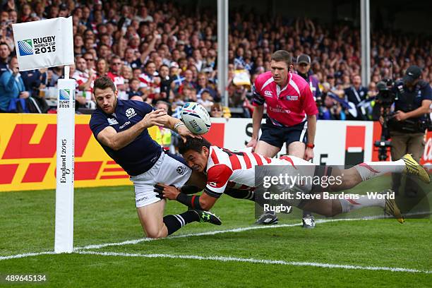 Tommy Seymour of Scotland is tackled by Ayumu Goromaru of Japan as he fails to go over for a try during the 2015 Rugby World Cup Pool B match between...