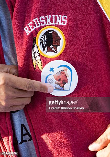 Vendor wears a button featuring Pope Francis on his Redskins football team jacket, near the Ellipse, September 23, 2015 in Washington, DC. The Pope...