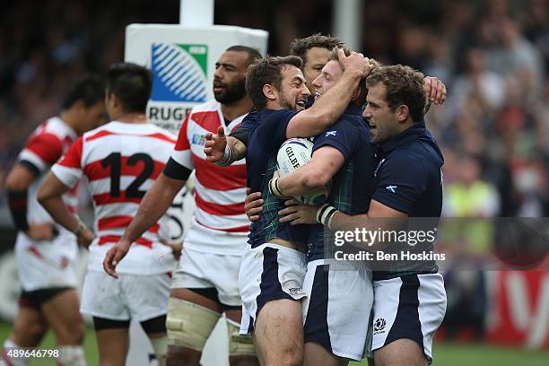 Finn Russell of Scotland is congratulated by team mates after scoring his teams fifth try during the 2015 Rugby World Cup Pool B match between...