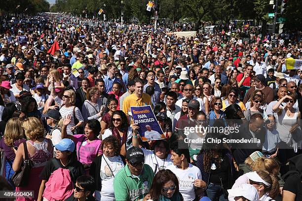 People walk down Constitution Avenue and head out of the security zone after Pope Francis paraded past along the National Mall September 23, 2015 in...