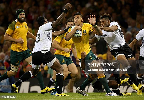 Israel Folau of Australia is tackled by Vereniki Goneva and Metuisela Talebula of Fiji during the 2015 Rugby World Cup Pool A match between Australia...