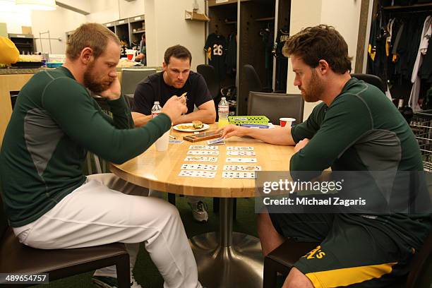 Brandon Moss and Jake Elmore of the Oakland Athletics play cards in the clubhouse prior to the game against the Texas Rangers at O.co Coliseum on...