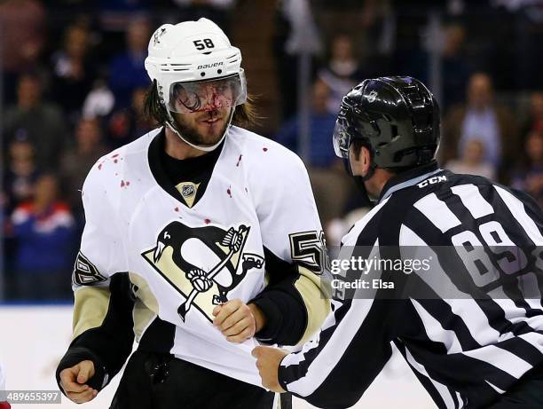 Linesman Steve Miller talks to Kris Letang of the Pittsburgh Penguins after a fight at the end of their 3 to 1 loss to the New York Rangers during...