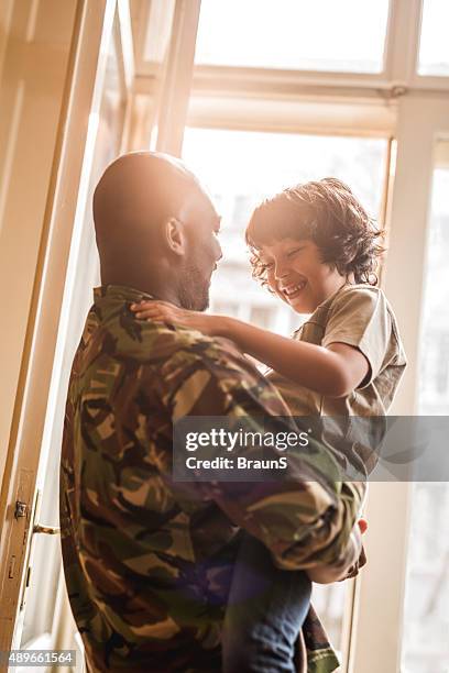 happy african american soldier talking to his son at home. - heroes 2015 arrivals stock pictures, royalty-free photos & images