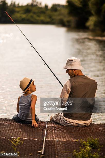 vue arrière d'un père et fils, parler en la pêche. - freshwater fishing photos et images de collection