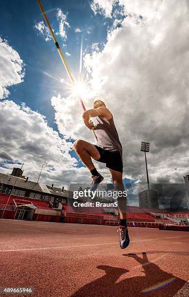 unter ansicht eines mannes während einer stabhochsprung wettbewerb. - mens pole vault stock-fotos und bilder