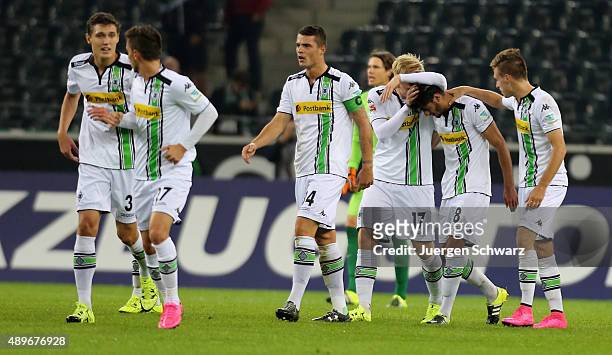 Mahmoud Dahoud of Moenchengladbach is hugged by Patrick Herrmann and Oscar Wendt after scoring during the Bundesliga match between Borussia...