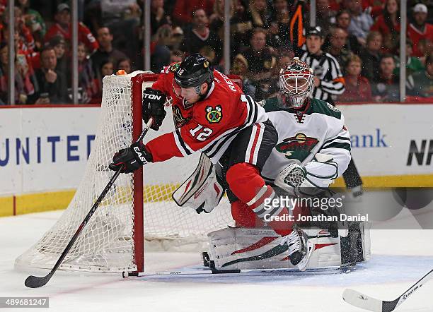 Peter Regin of the Chicago Blackhawks crahses into the net next to Ilya Bryzgalov of the Minnesota Wild in Game Five of the Second Round of the 2014...