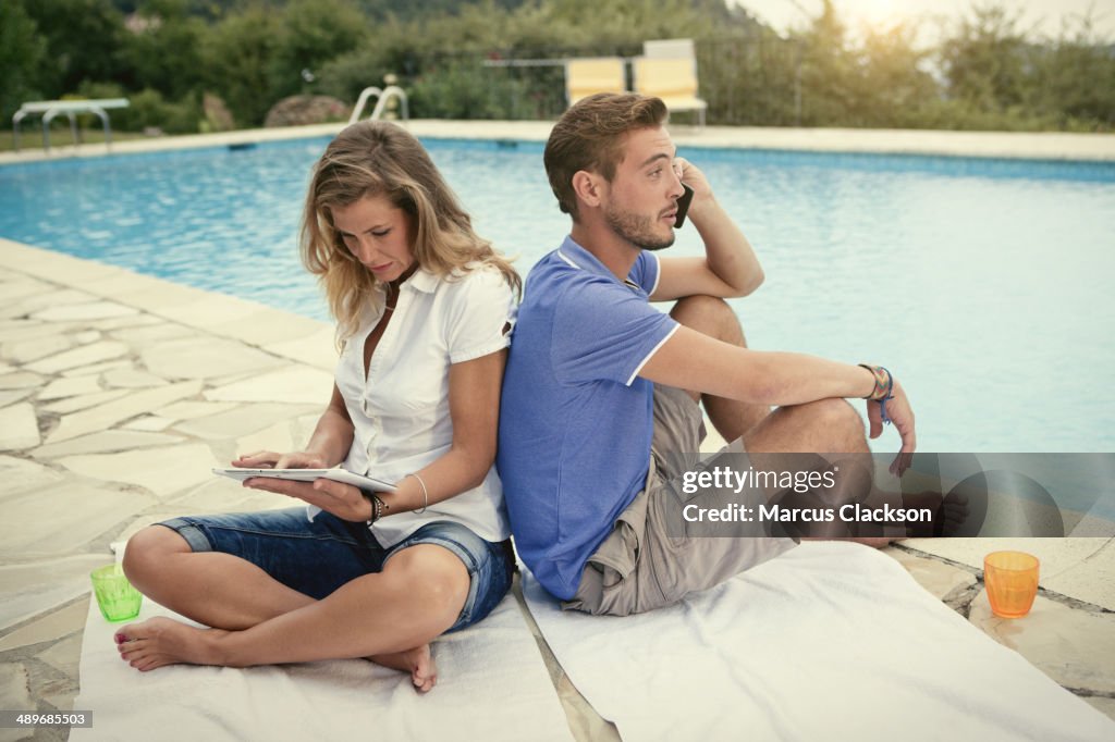 Couple on holiday in France sitting by the pool